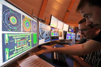 scientists look at a computer screen at the control center of the CERN in Geneva, September 10, 2008