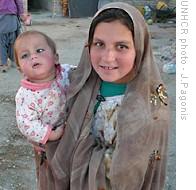 Afghan girl carrying her infant sibling in Iran's Sistan Baluchistan province