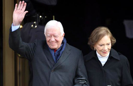 Former President Jimmy Carter is accompanied by his wife, Rosalynn, as he waves to the assembled crowds