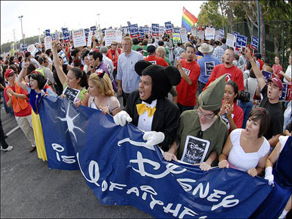 Protesters dressed as Disney characters, including Mickey Mouse, lead a march from the Paradise Pier Hotel to the main entrance of Disneyland during a demonstration protesting Disney's treatment of hotel workers