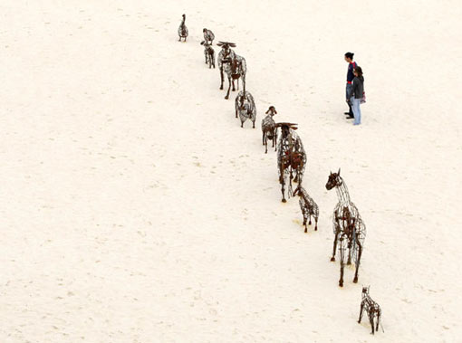 the free outdoor exhibition, now in its 12th year, stretches for two-kilometres (1.24 miles) along the coastline popular with walkers, joggers and tourists. Visitors view a work by artists Andy Townsend and Suzie Bleach