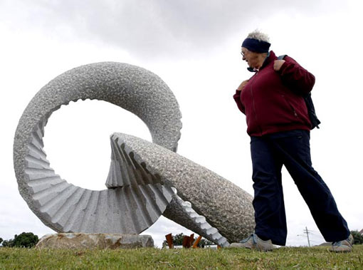 a woman inspects a work by Japanese artist Keizo Ushio