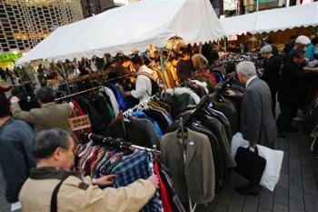 Tents selling secondhand clothes are crowded in front of a busy train station in Tokyo Monday, Nov. 17, 2008