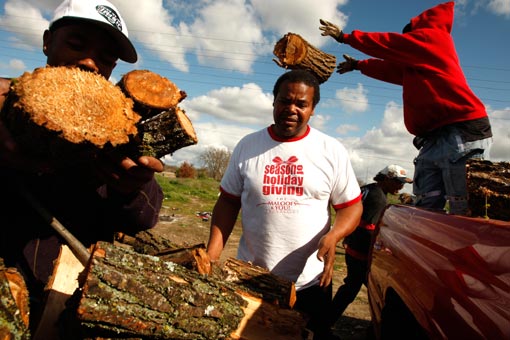 Homeless truck driver Michael Elliott, 52, center, and his friend Steve, left, collect firewood donated to tent city residents by Arthur McDonald