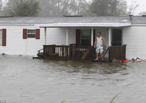 Nowhere to go: Jarod Wilton looks at the flood waters rising to his doorstep, in Alliance, North Carolina