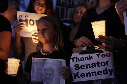 Olivia Kelly, 8, left, and Dion Osborne, 11, rear, hold signs in memory of Sen. Kennedy at a candle light vigil in Miami.