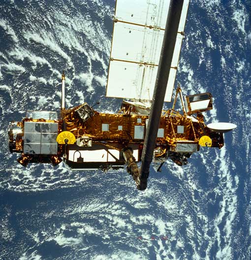 the Upper Atmosphere Research Satellite hangs in the grasp of the Remote Manipulator System during deployment from Space Shuttle Discovery, September 1991