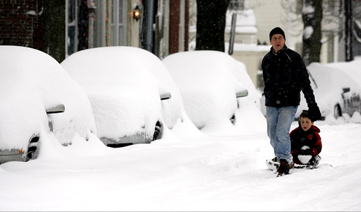 Pedestrians walk down a snow-covered road in Old Town, Alexandria, Va.